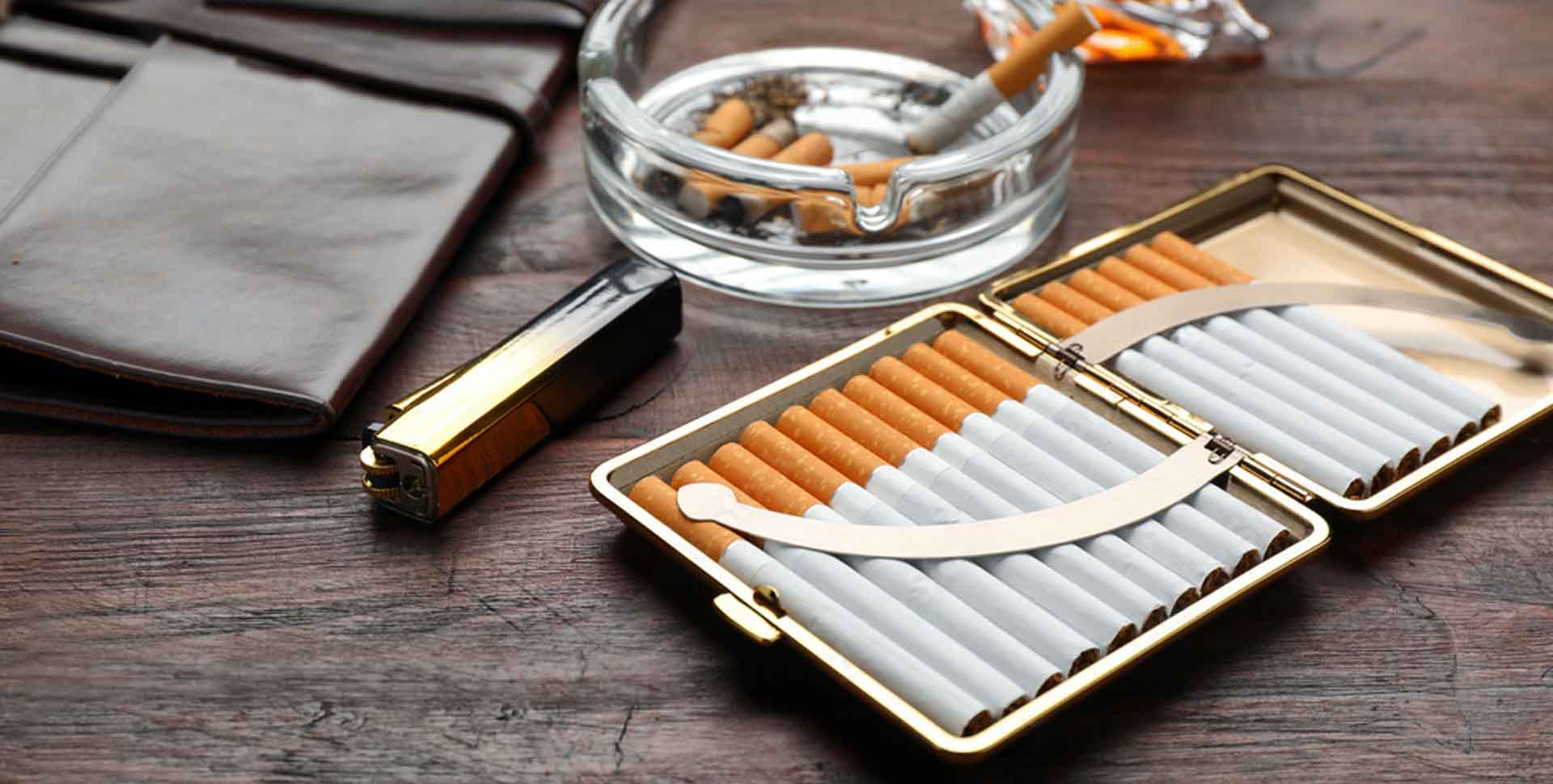Tabatierka plná cigariet, priehľadný sklenený popolník, kožené puzdro na tabak, zapaľovač